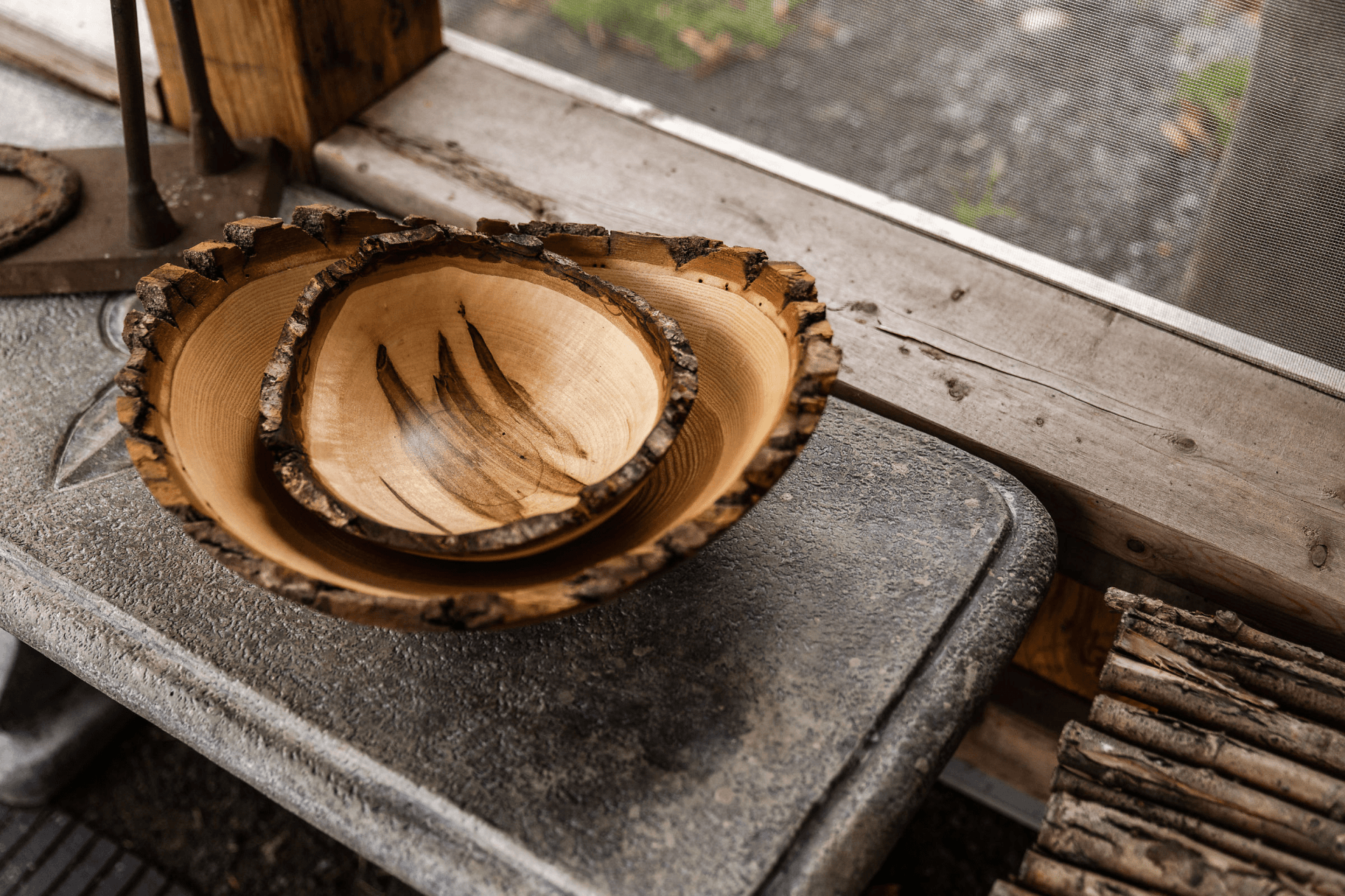 Two wooden bowls sitting on a stone ledge
