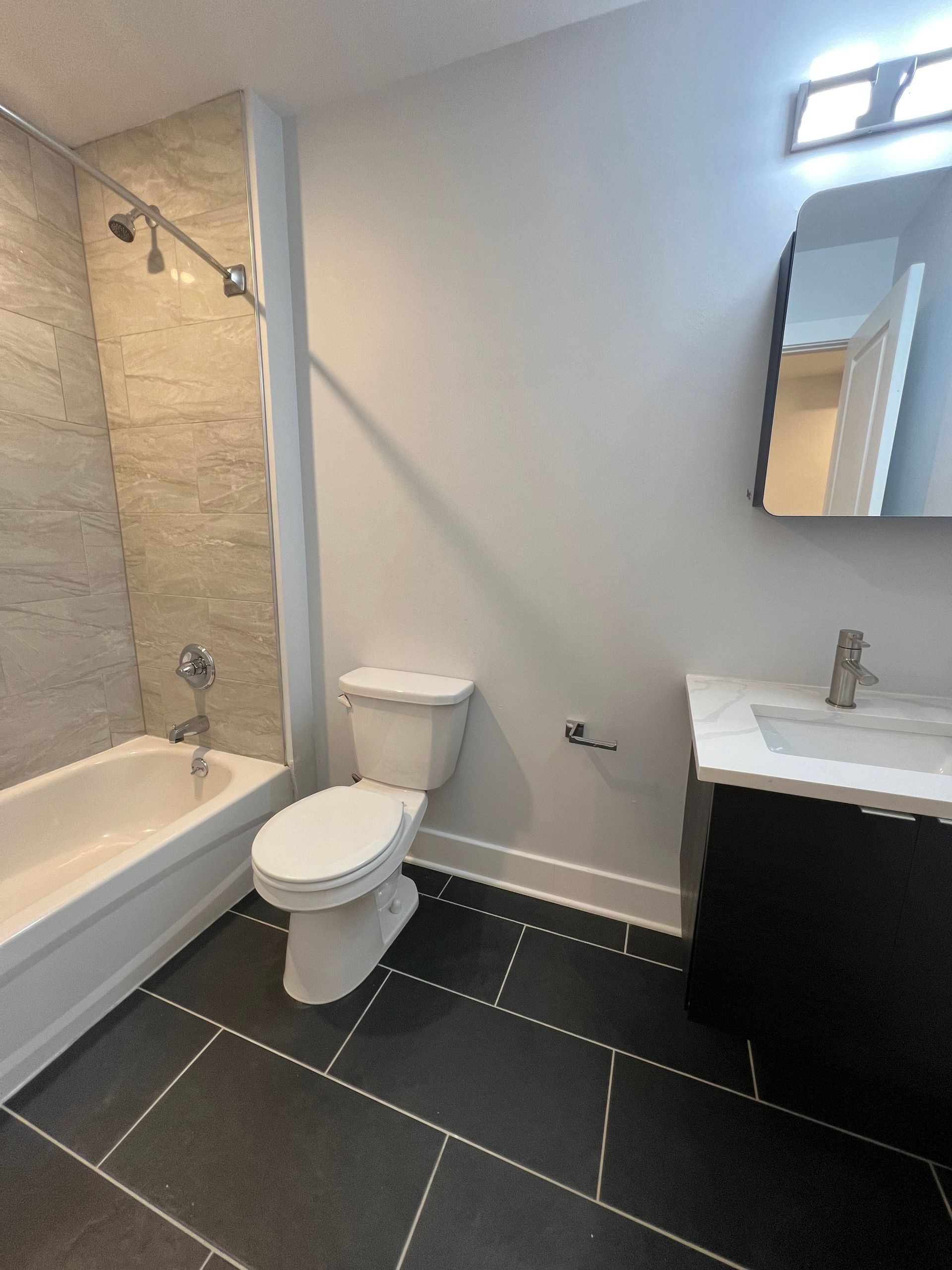 A bathroom with a toilet a sink and a bathtub