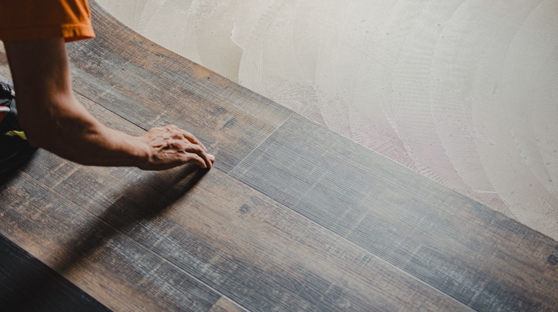 Person installing dark wood flooring.