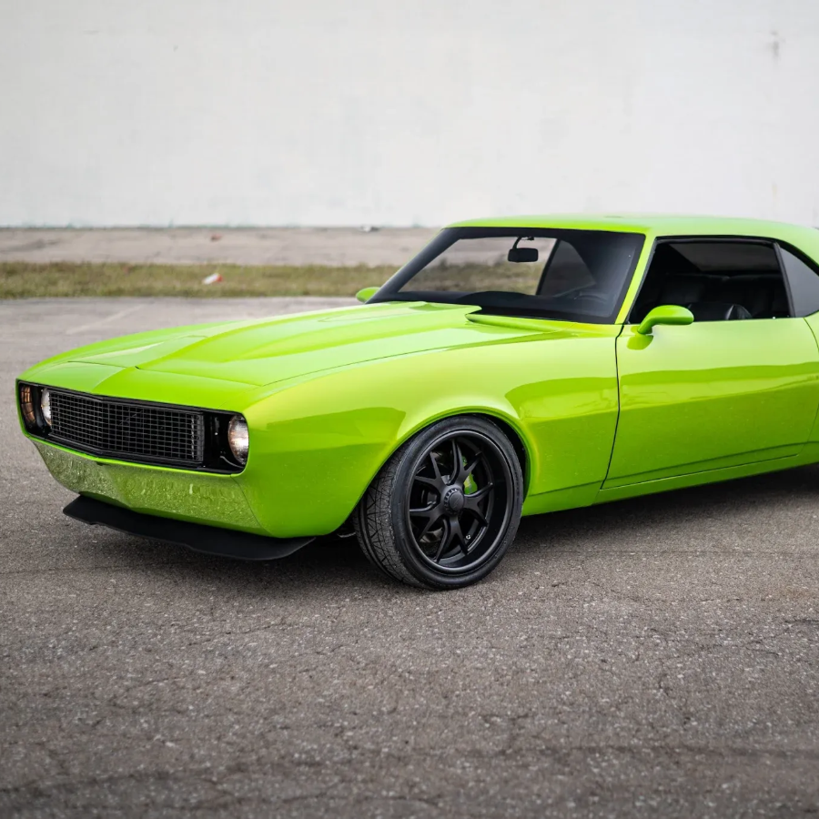 Bright green classic muscle car parked on pavement, side view with black wheels.