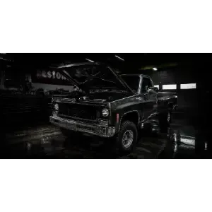 Black classic pickup truck with hood open in a dim garage, reflected on a wet floor