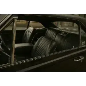 Black car interior with ribbed leather seats, viewed through the side window