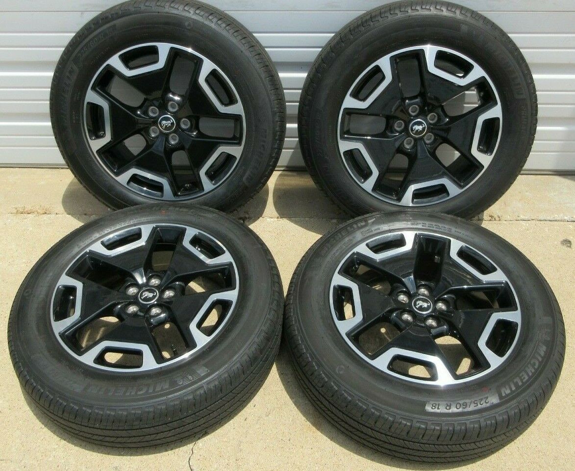A set of four black and silver wheels and tires