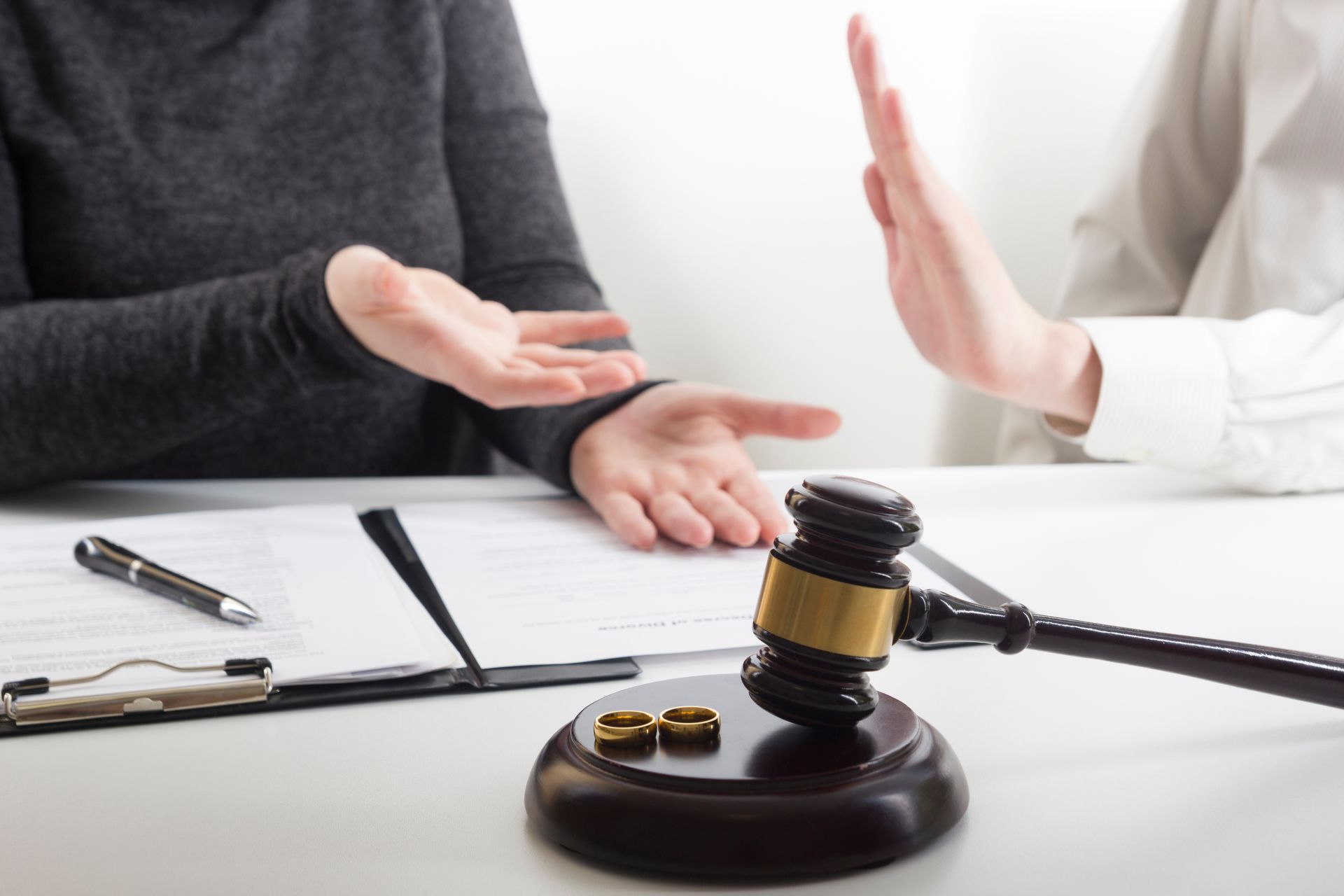 Wedding rings beside a judge's gavel, symbolizing divorce and legal separation proceedings Wedding rings beside a judge's gavel, symbolizing divorce and legal separation proceedings