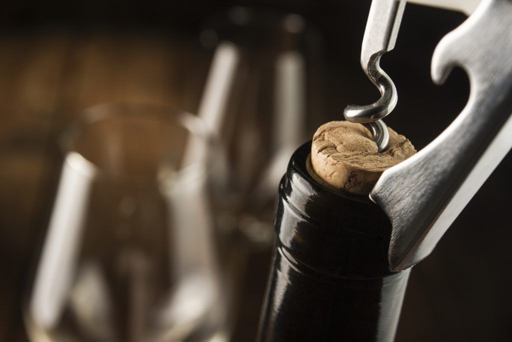 Een kurkentrekker wordt gebruikt om een ​​fles wijn te openen.