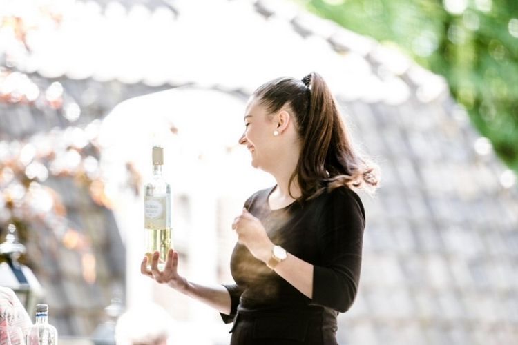 Een vrouw houdt een fles wijn in haar hand.