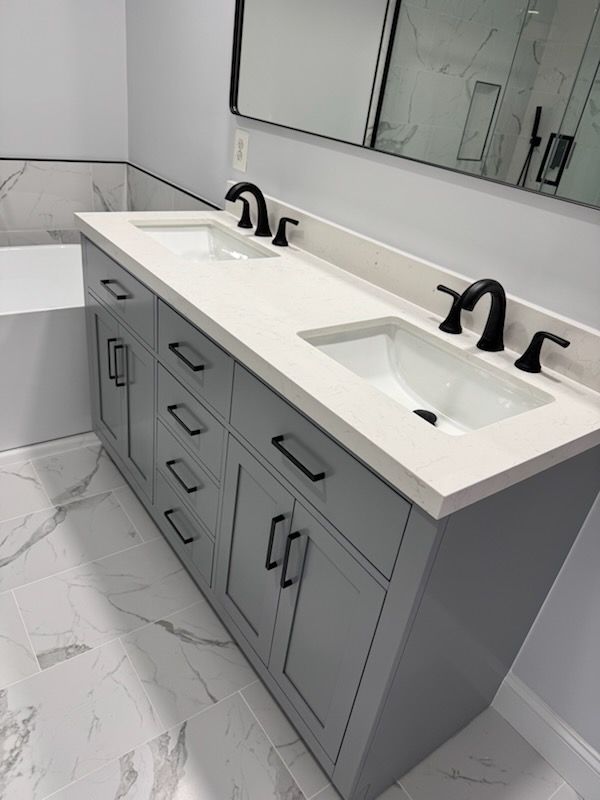 Modern double-sink bathroom vanity with gray cabinets, white countertop, and large mirror.