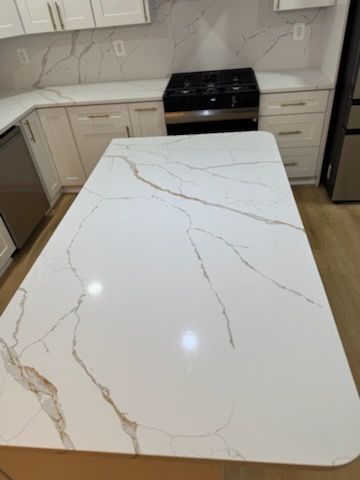 White marble-look kitchen island countertop with gold veining in a modern kitchen