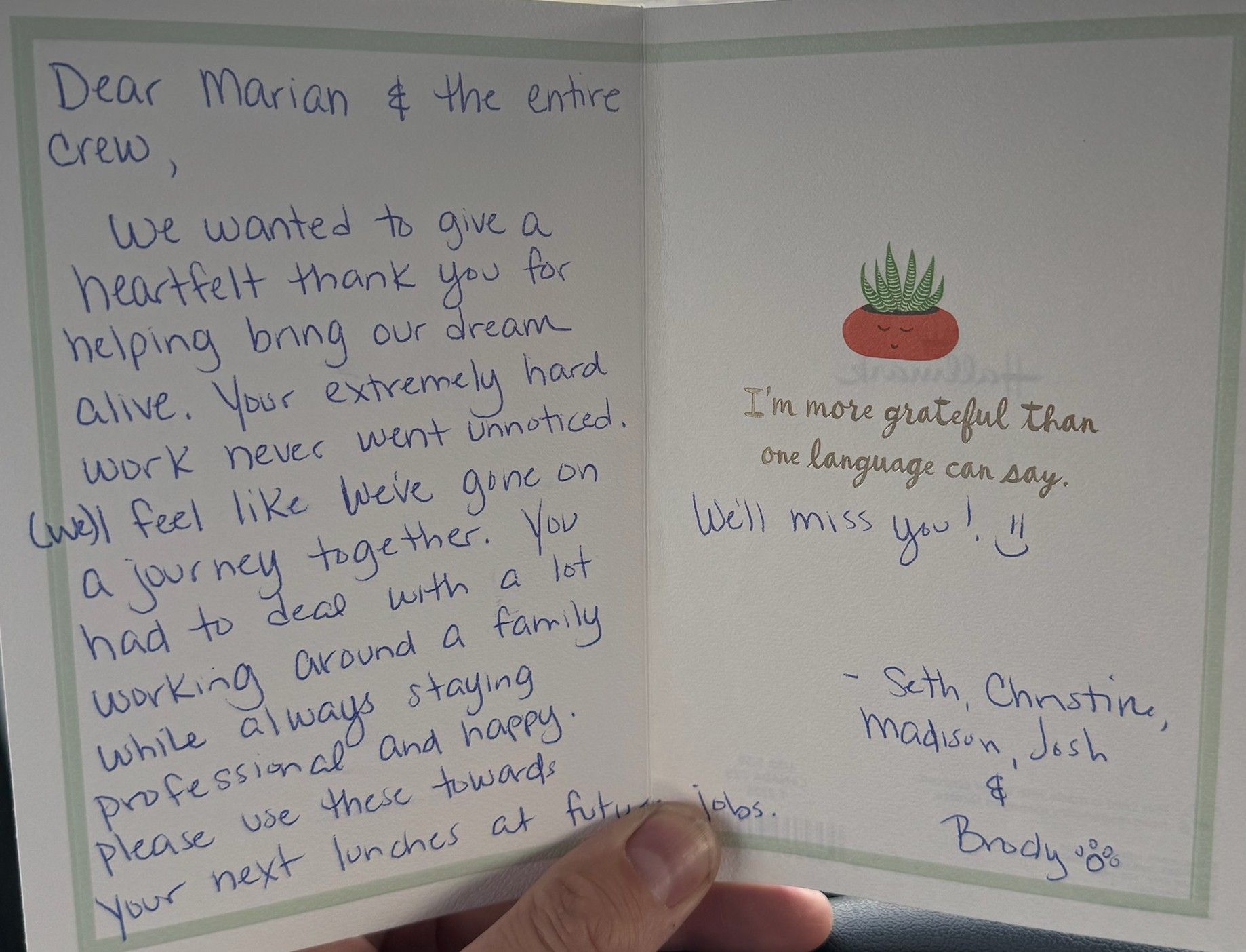 A person is holding a card that says dear marian & the entire crew