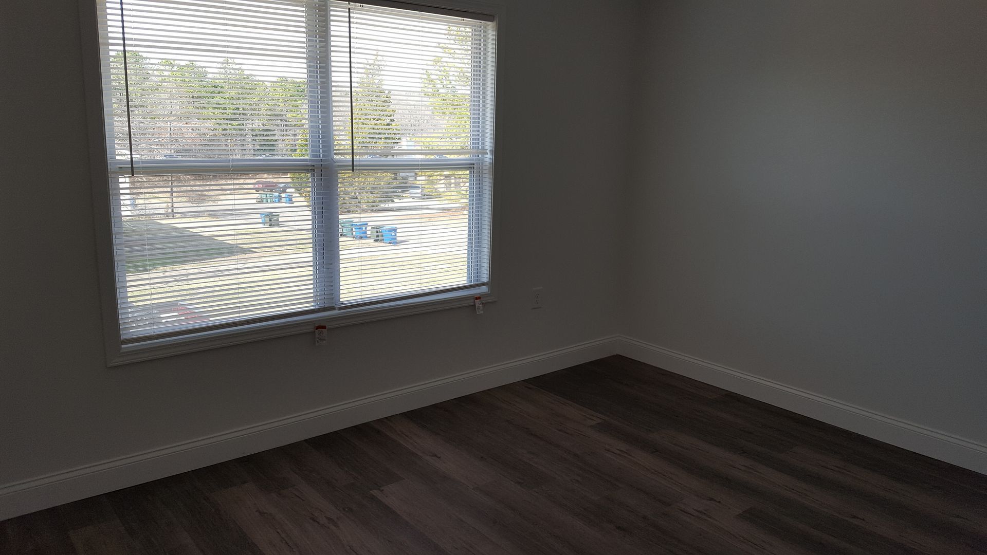 An empty room with a window and blinds on it.