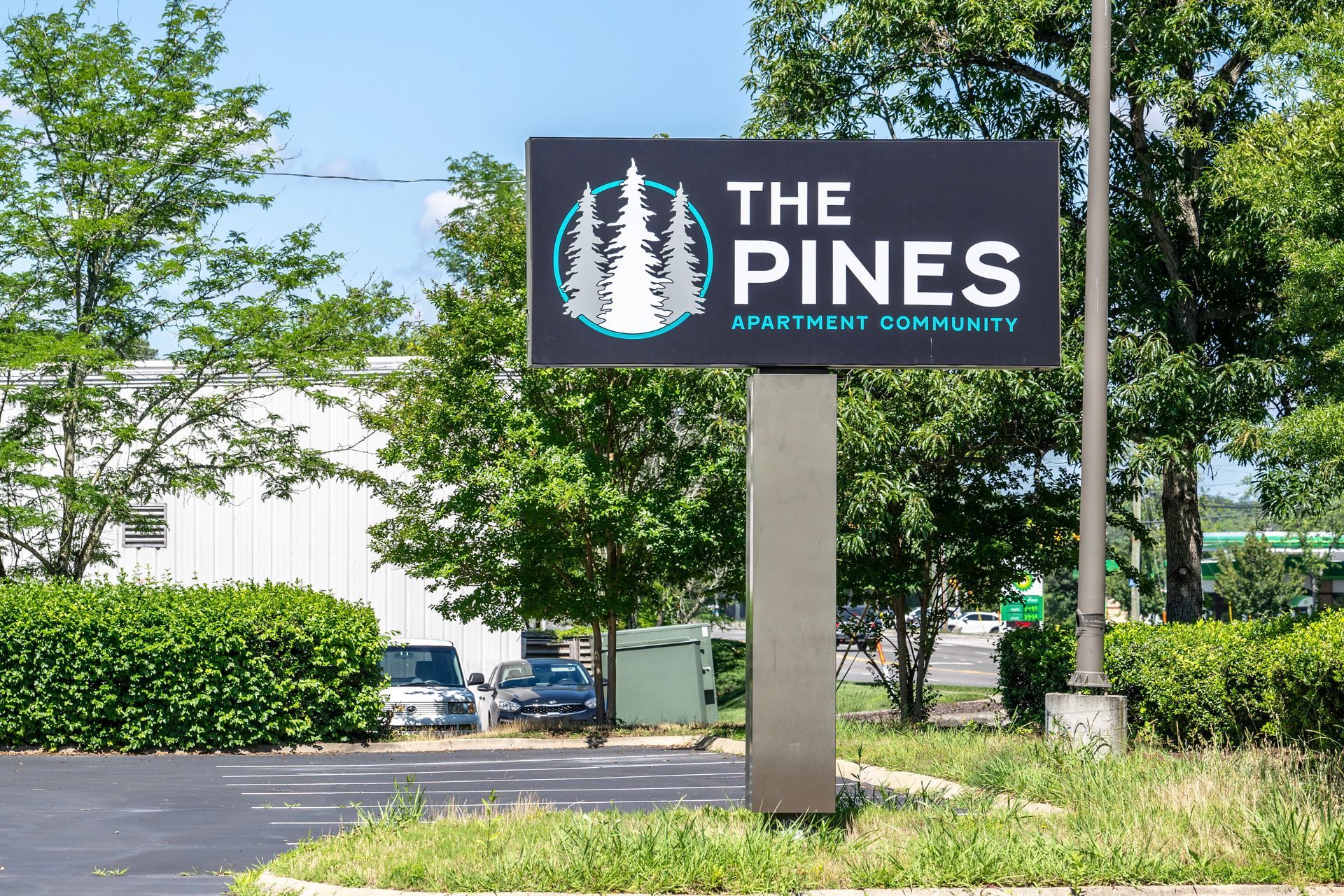 A large sign for the pines apartment community
