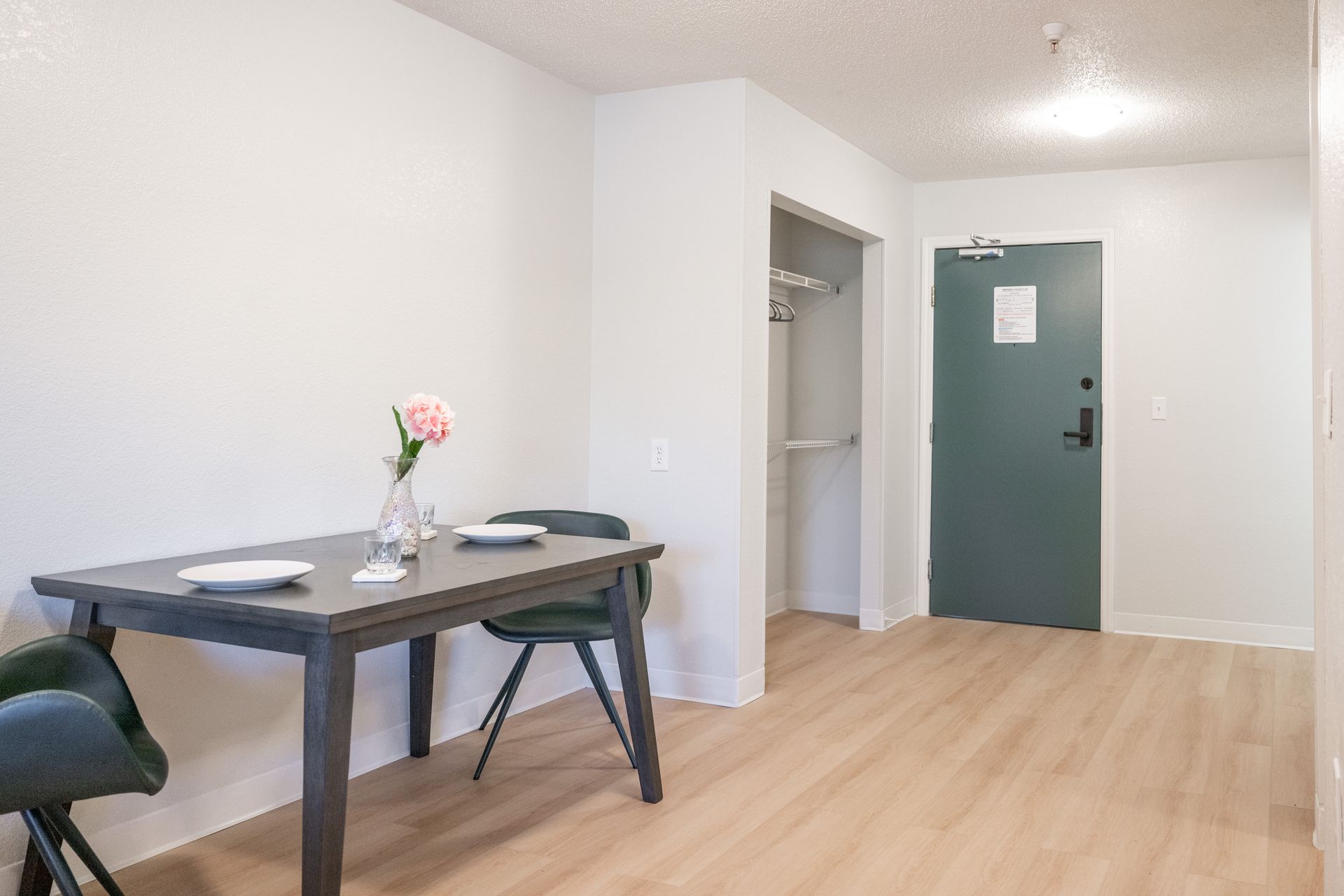 A living room with a table and chairs and a door.