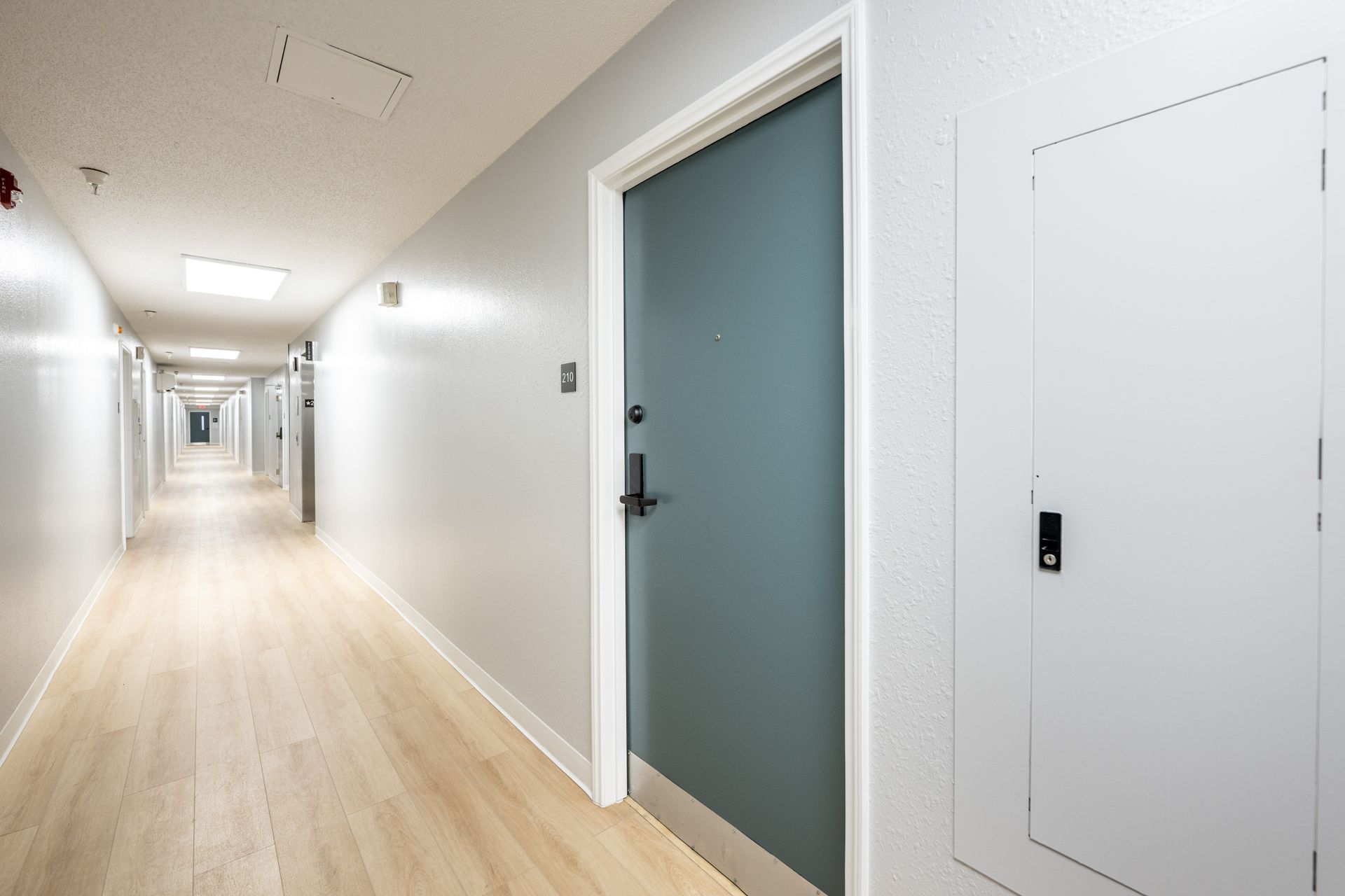 A long hallway with a door in the middle of it