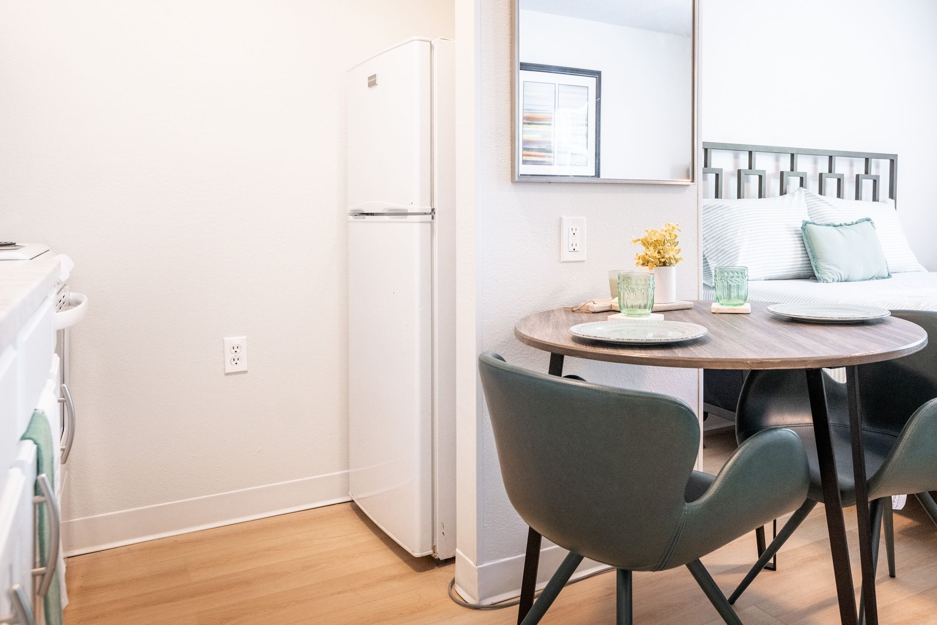 A kitchen with a table and chairs and a refrigerator.