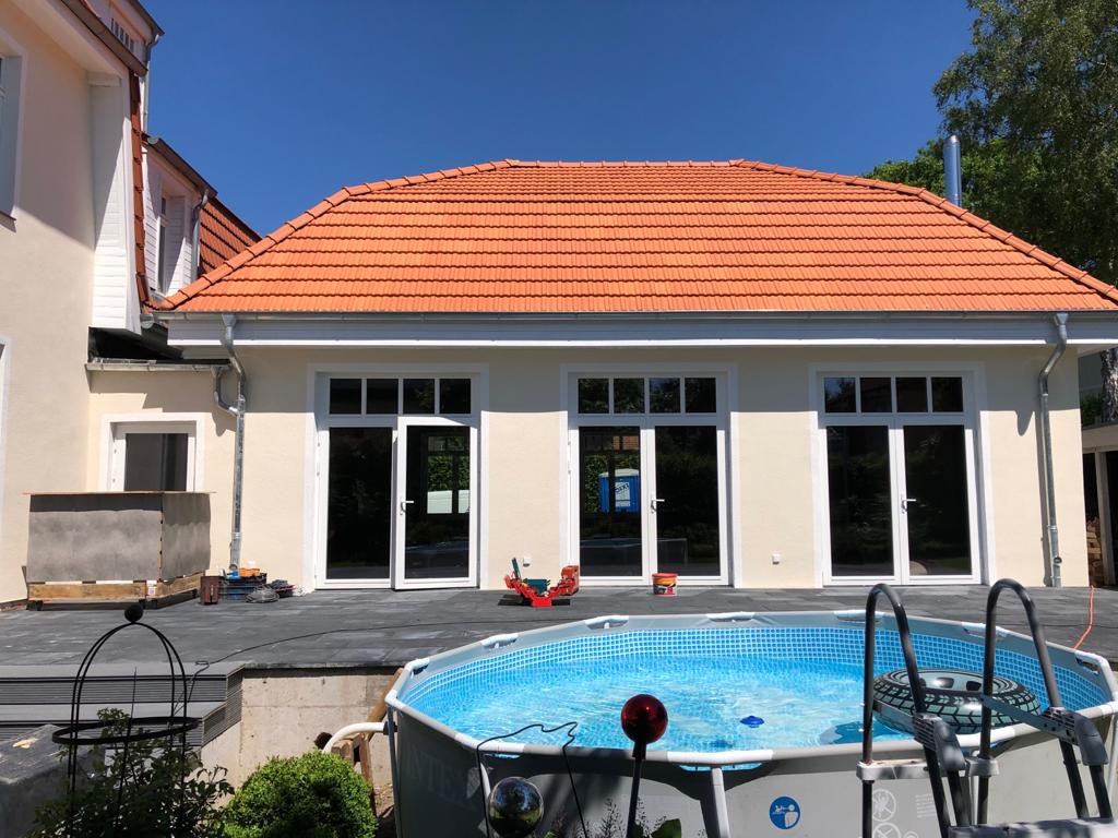 Ein großes Haus mit einem Swimmingpool davor.