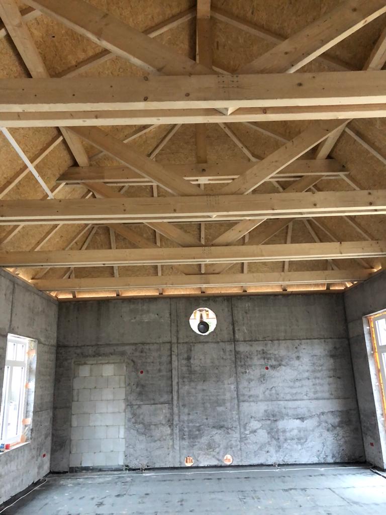 Ein Raum mit einer Holzdecke und einer Betonwand.