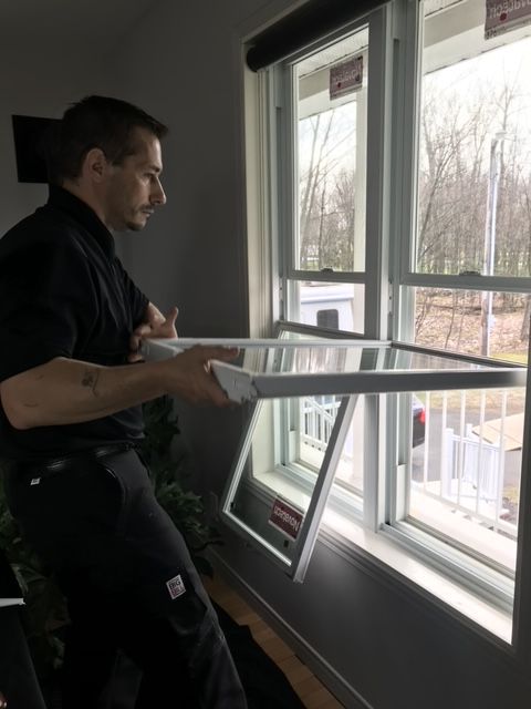Un homme se tient devant une fenêtre et regarde dehors.