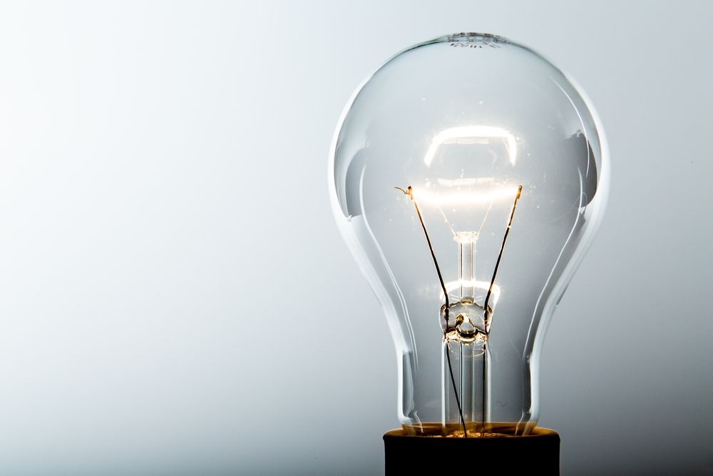 Lit Incandescent Light Bulb, Glass and Metal — Brian Williams Electrical Air Solar in Nambour, QLD