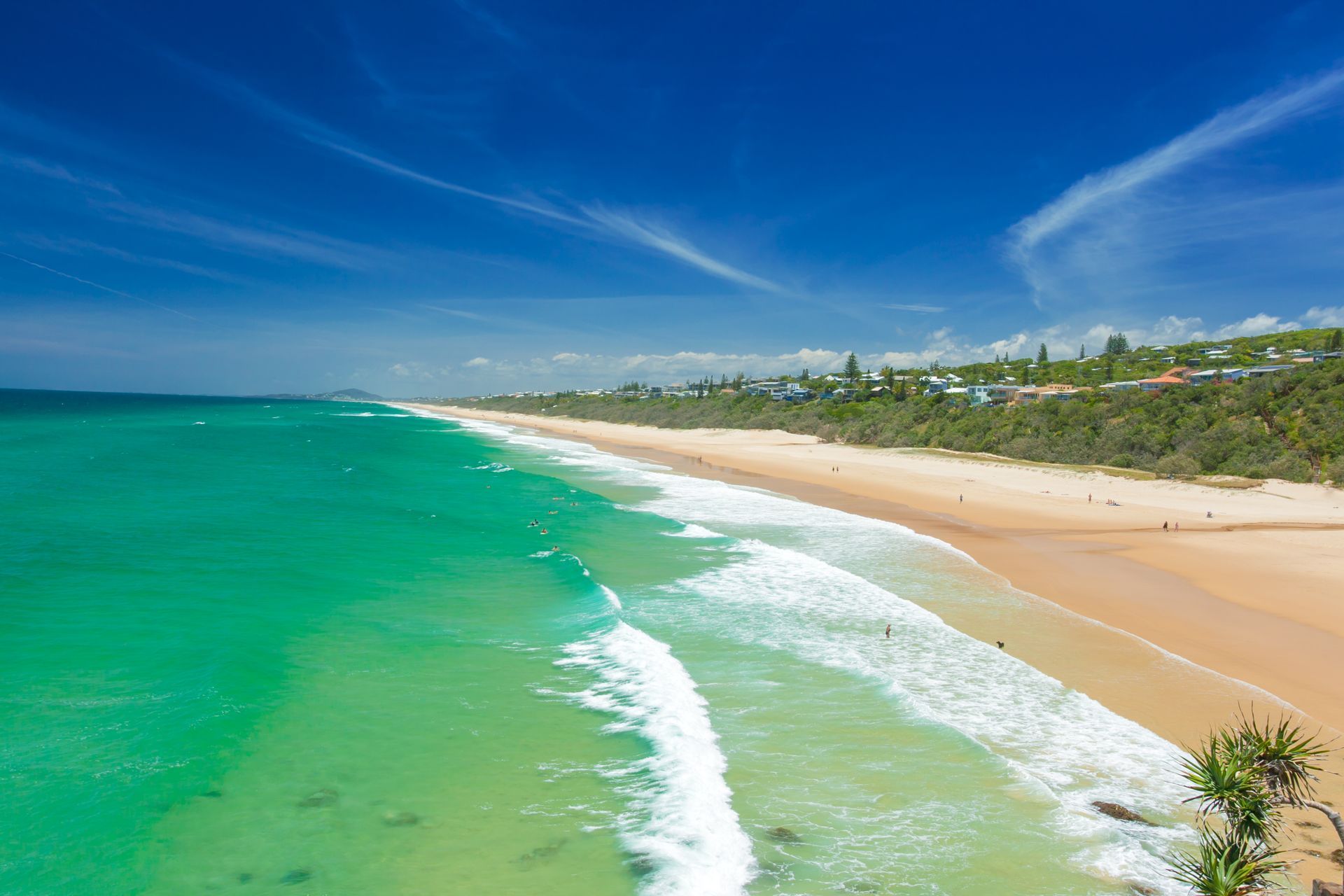 A Turquoise Ocean Waves Crash onto A Sandy Beach — Brian Williams Electrical Air Solar in Nambour, QLD