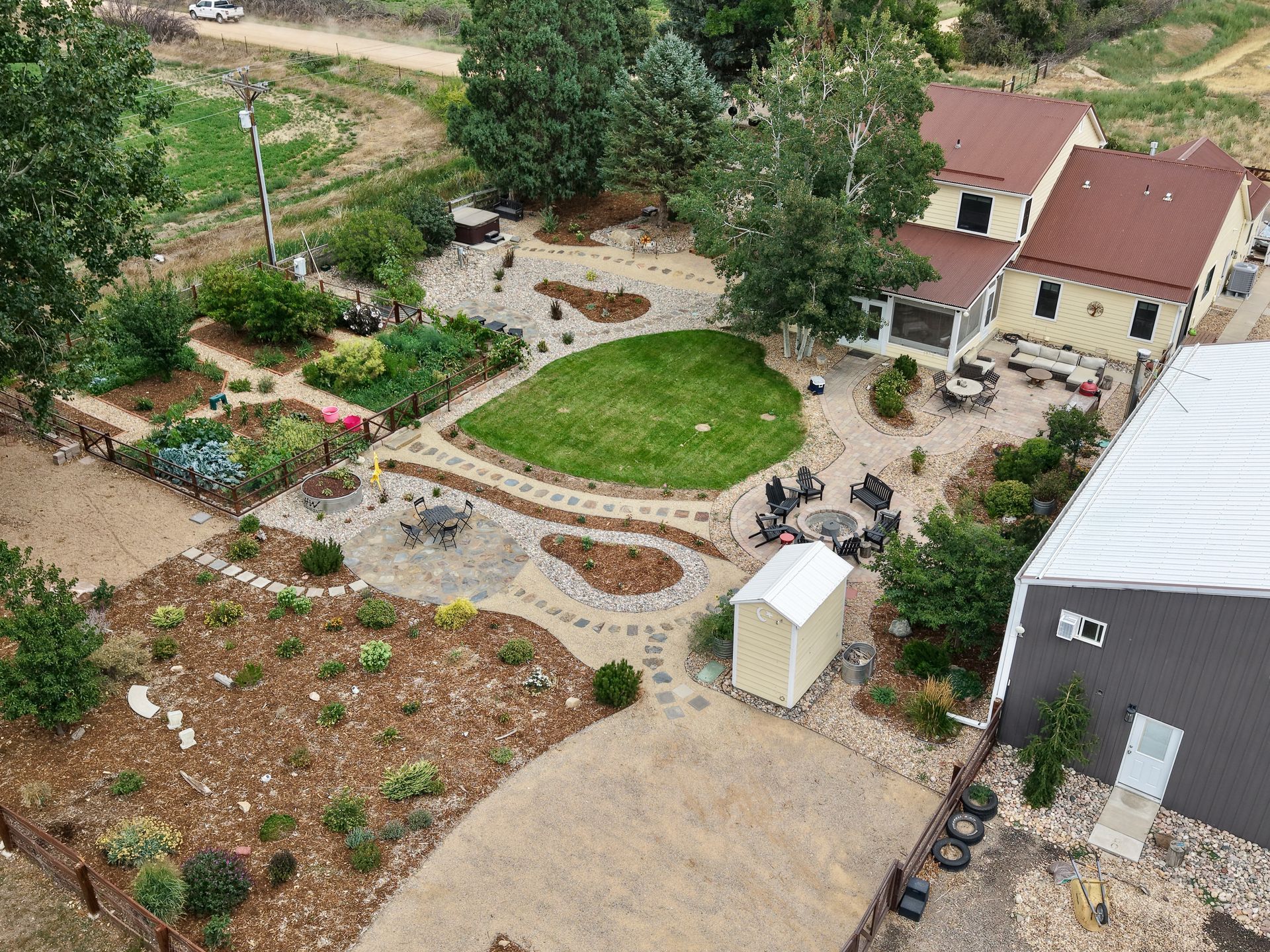 Stone steps in a park beside a stone wall, with people sitting at the top near a playground and grassy slope.