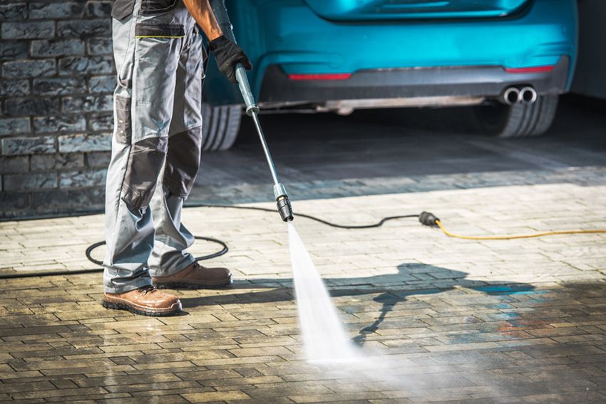 A Man is Using a High Pressure Washer to Clean a Driveway — Painters Geelong in Geelong, VIC