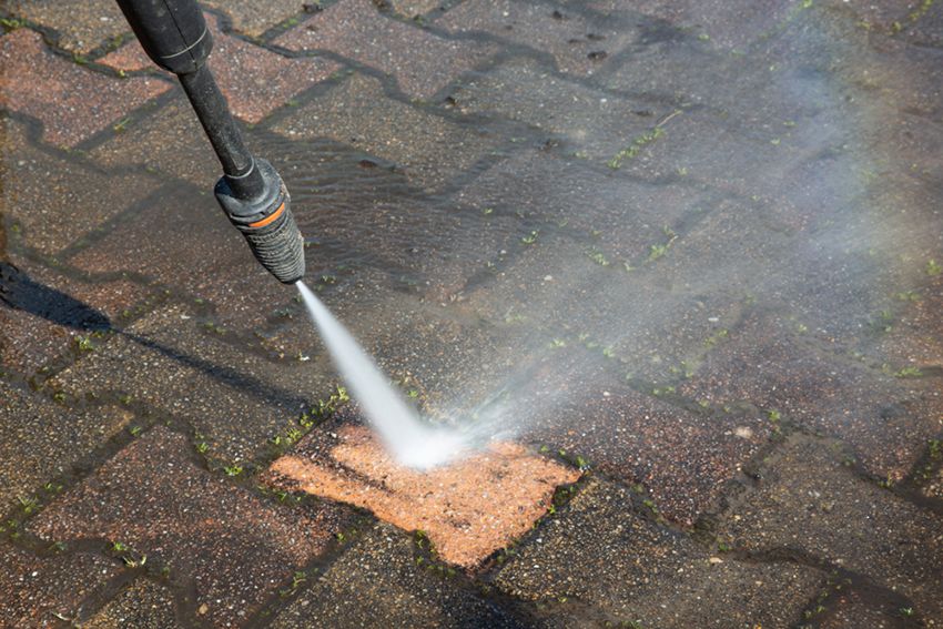 A Person is Using a High Pressure Washer to Clean a Brick Sidewalk — Painters Geelong in Geelong, VIC