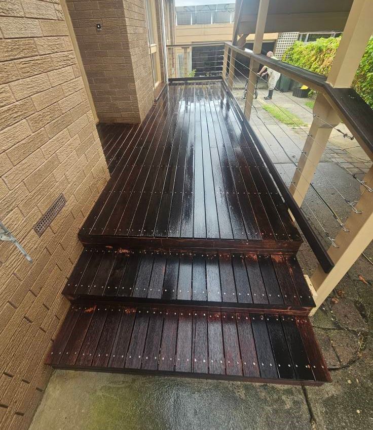 A Wooden Deck with Stairs Leading Up to It Next to a Brick Building — Painters Geelong in Geelong, VIC