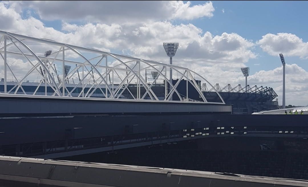 A Long Hallway with a Green Exit Sign on the Ceiling — Painters Geelong in Geelong, VIC