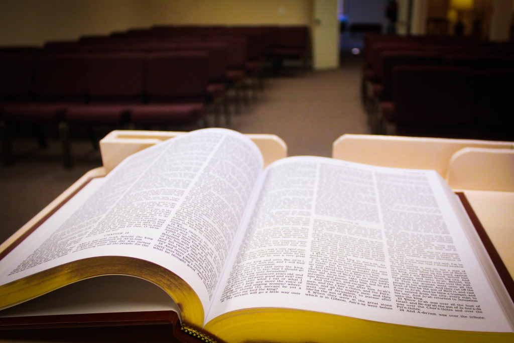 Open Bible on a pew in a dimly lit church sanctuary