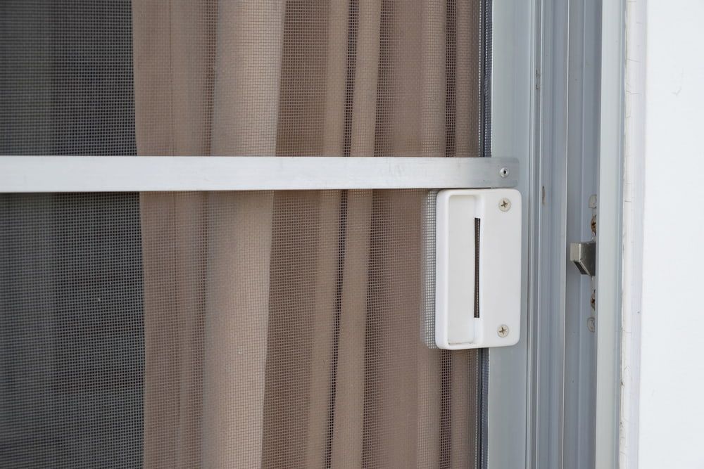 A Screen Door With A Curtain Behind It — Clearshield Security Screens in Bomaderry, NSW
