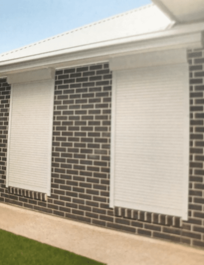 A Large White Building With a Lot of Garage Doors — Clearshield Security Screens in Bomaderry, NSW