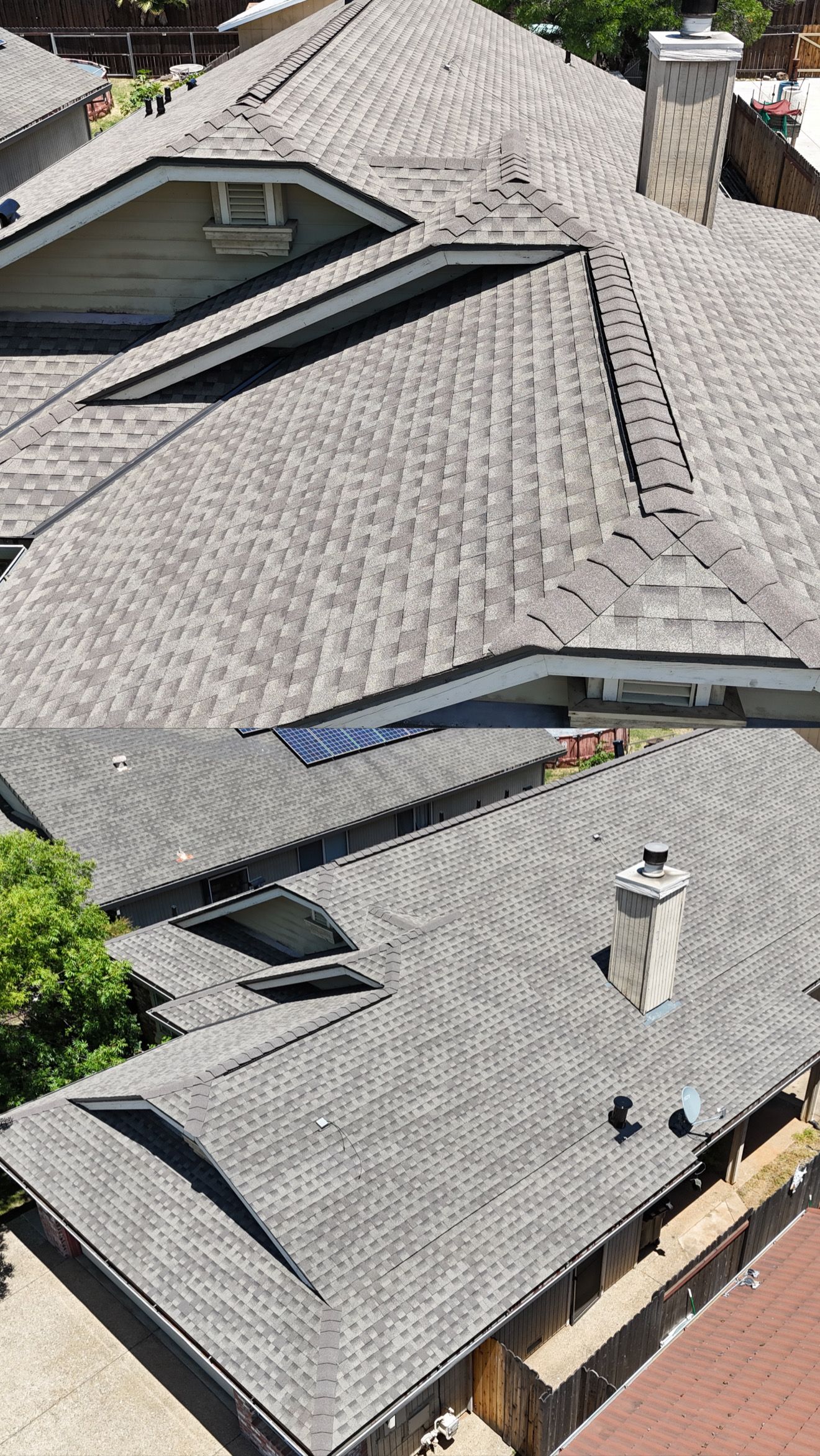 Aerial view of gray shingled house roofs with multiple skylights and chimneys