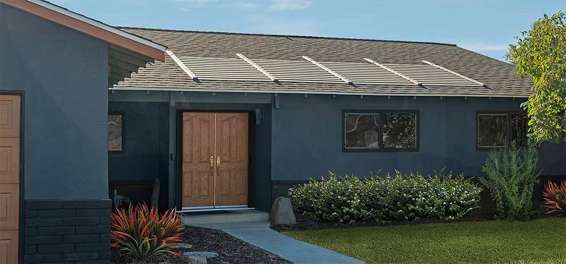 Single-story blue house with wooden front door, small window, and front lawn in daylight