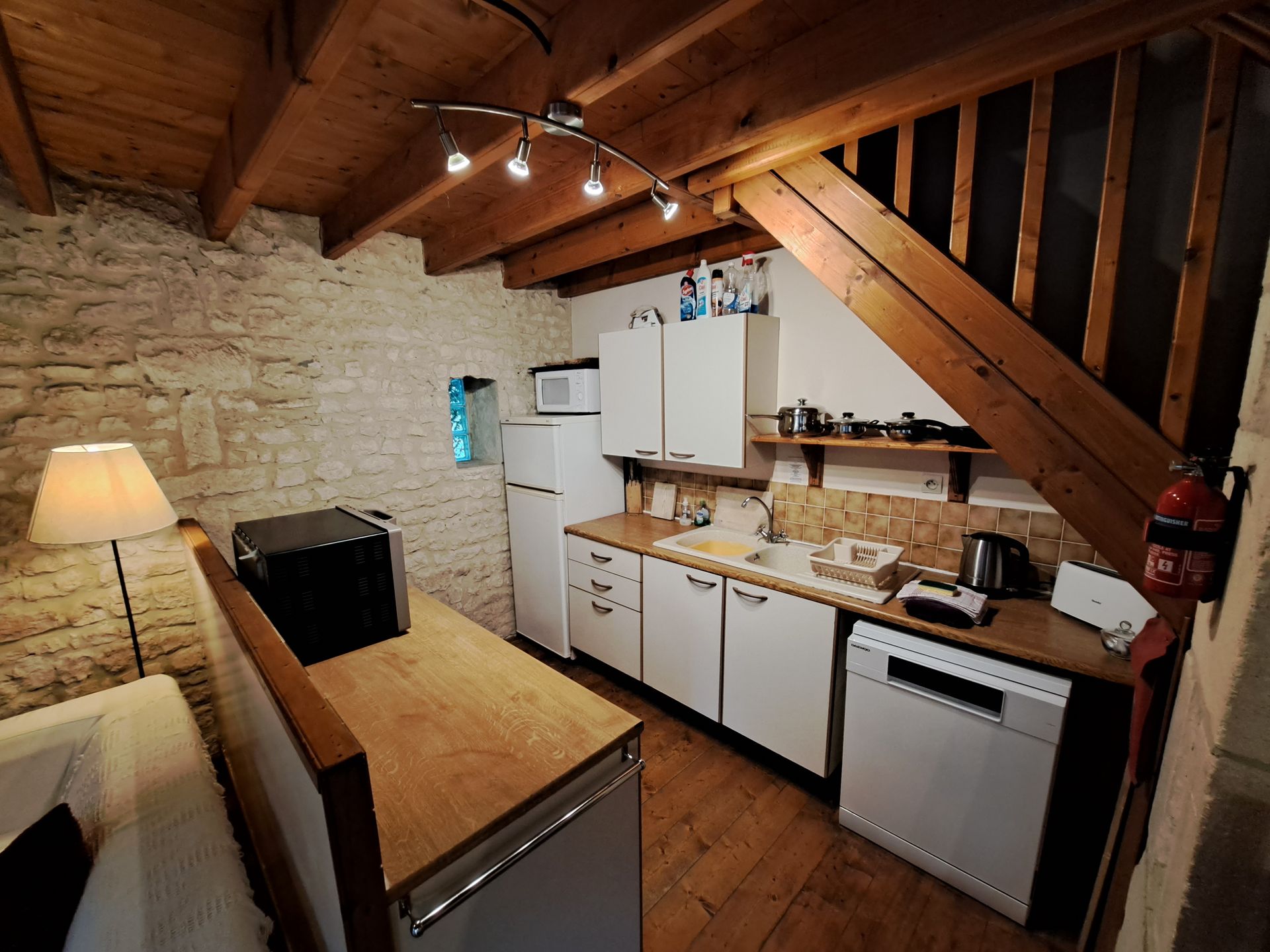 kitchenette with stone walls and wooden ceiling beams