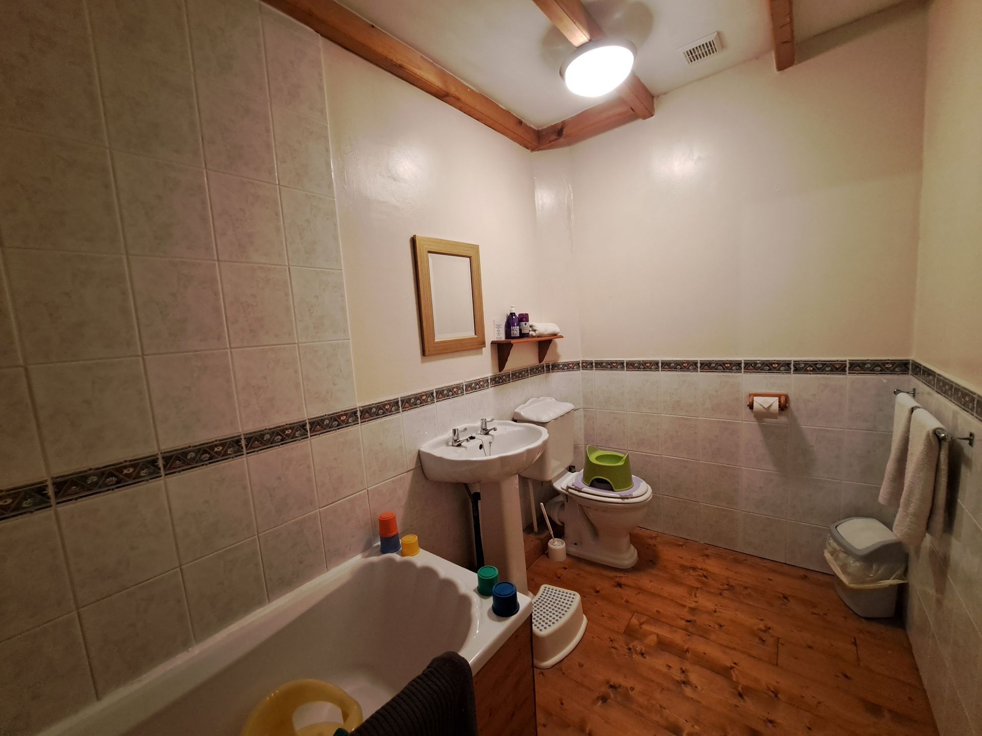 white bathroom suite with wooden floorboards