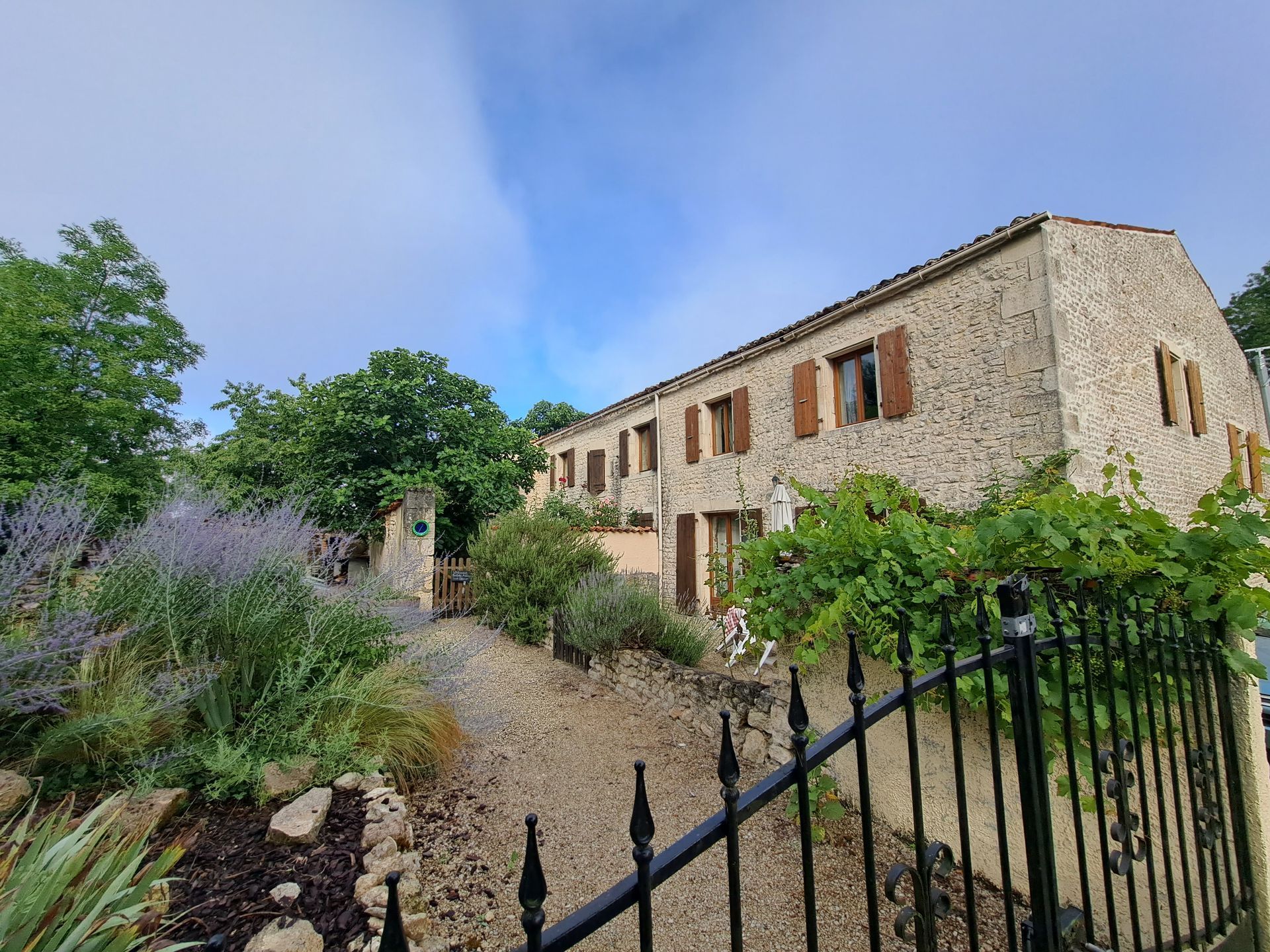 stone cottage with roman tiled roof and brown wood shutters