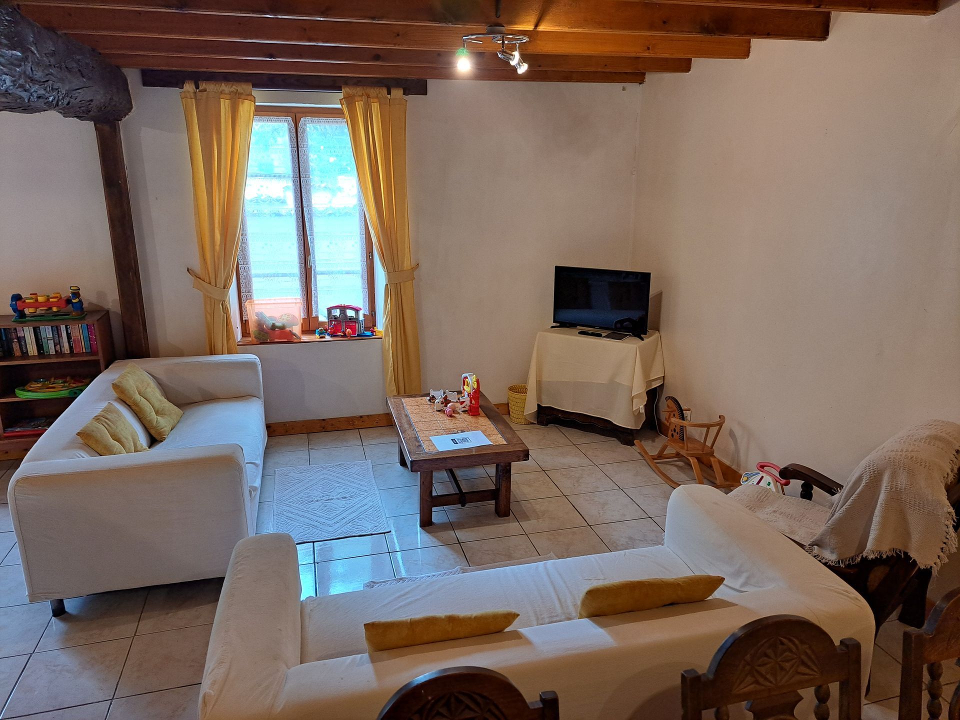 Sitting room with white tiled floor and cream ikea sofas