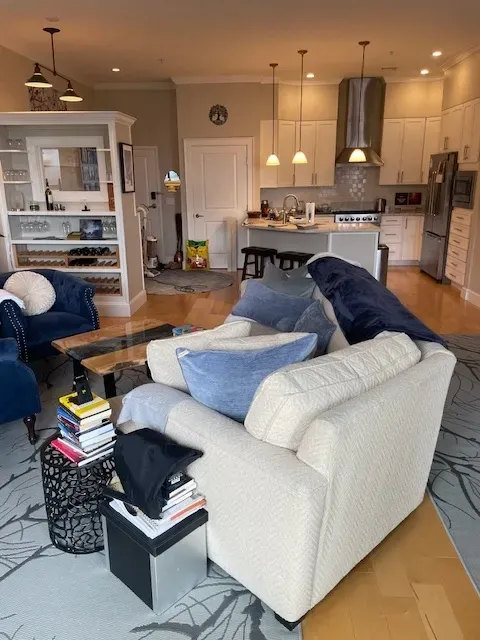 A living room with a white couch and blue chairs