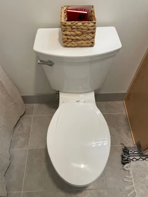 A toilet with a basket on top of it