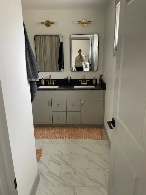 A bathroom with two sinks and a mirror