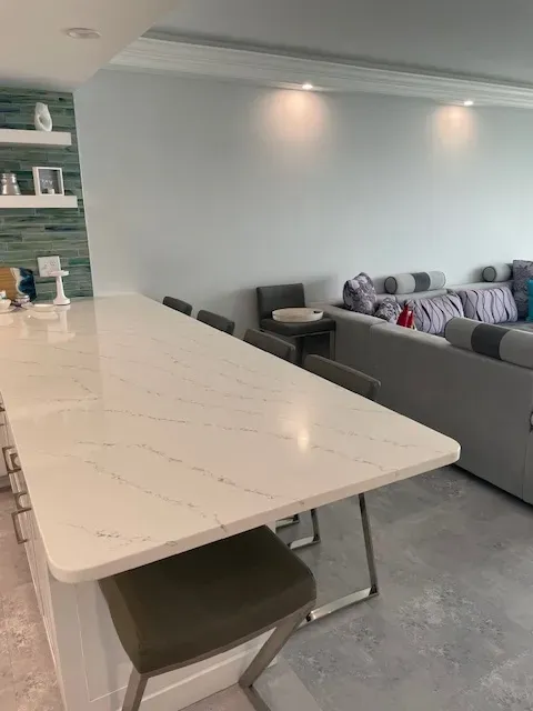 A living room with a long white table and chairs