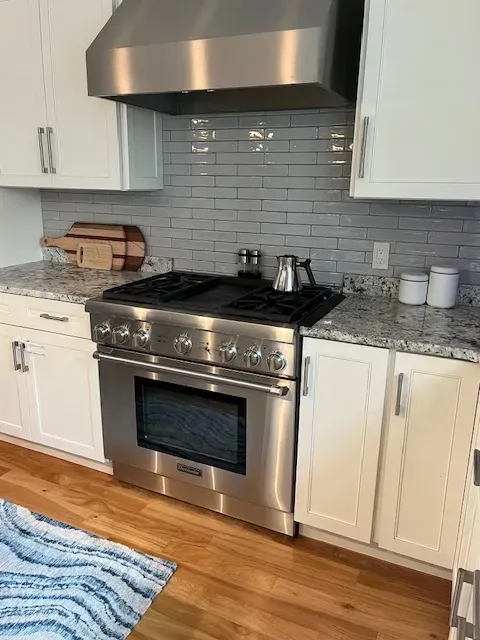 A kitchen with stainless steel appliances and white cabinets
