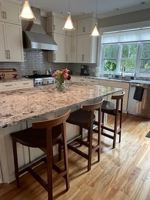 A kitchen with a granite counter top and stools