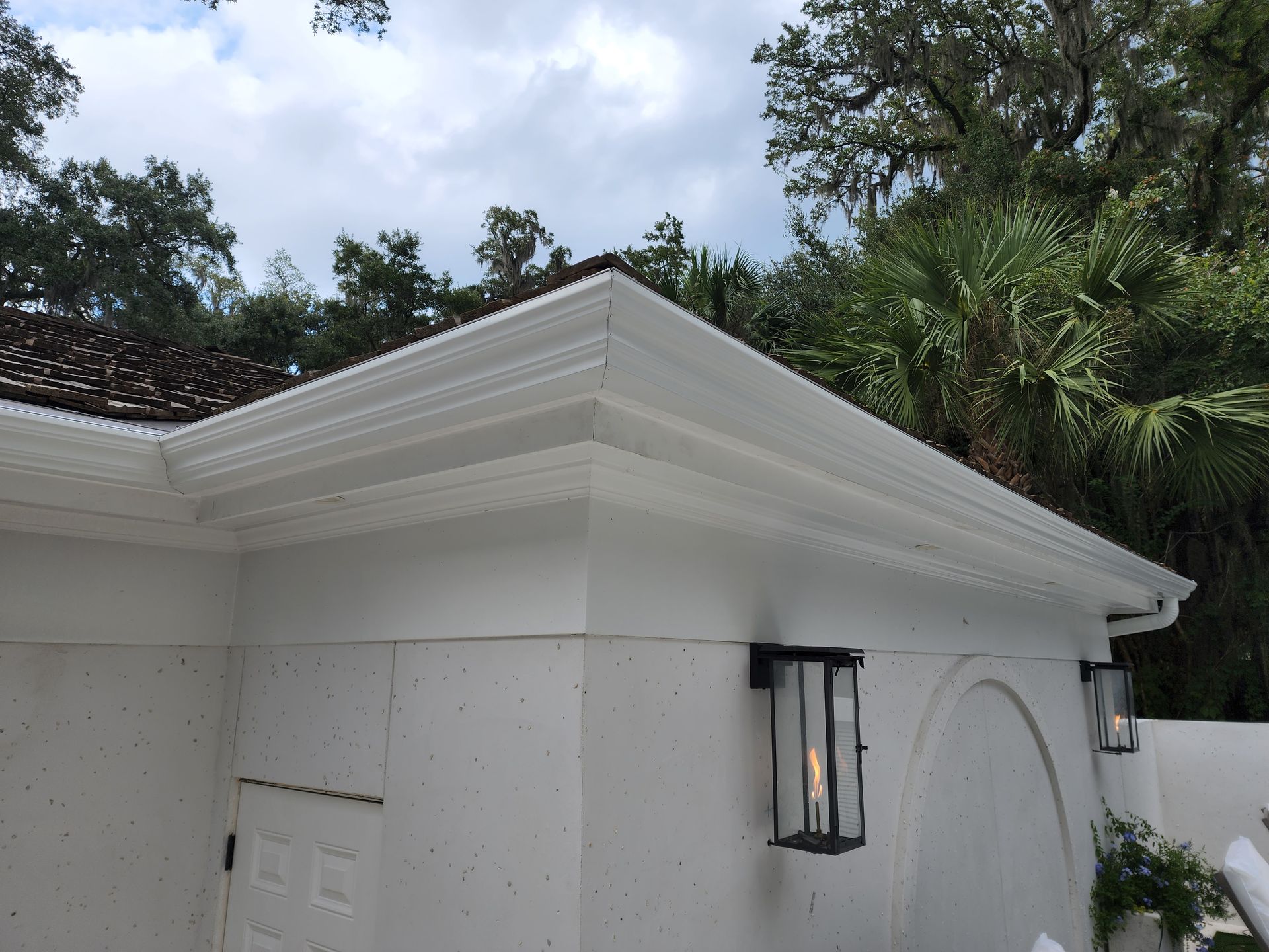 White building with gutters and a black lantern, exterior view.