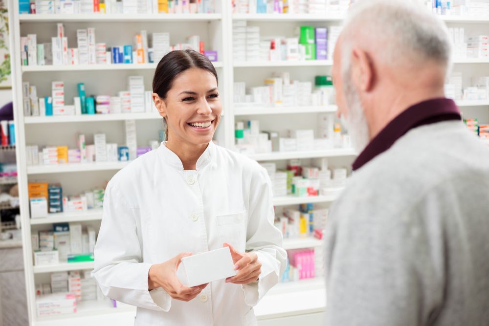 a Female Pharmacist is Using a Tablet Computer in a Pharmacy — Warners Bay Pharmacy In Warners Bay, NSW