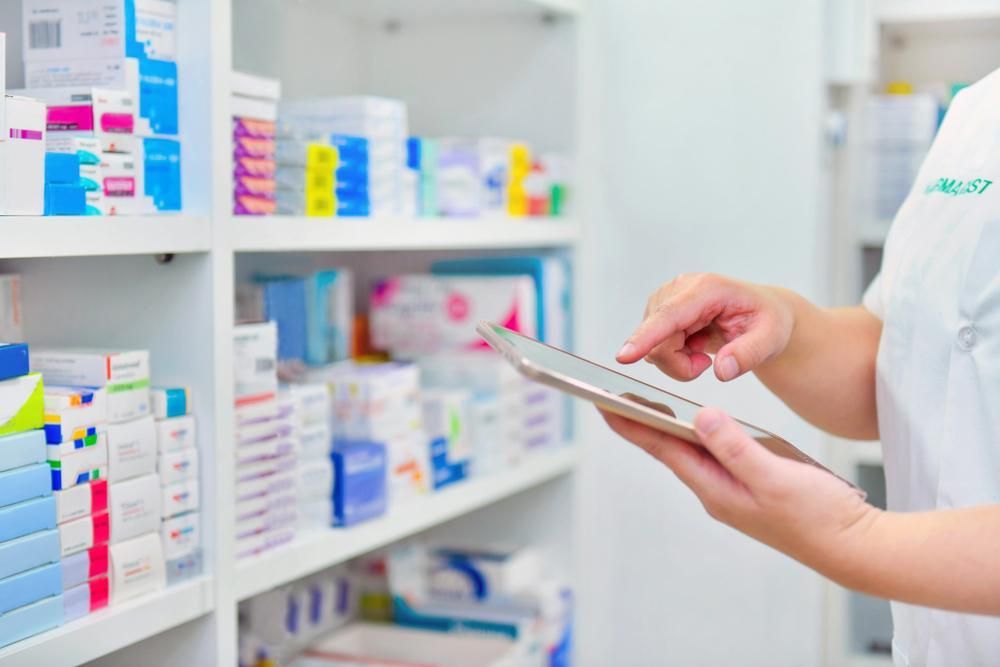 A Female Pharmacist Is Using A Tablet Computer In A Pharmacy — Warners Bay Pharmacy In Warners Bay, NSW