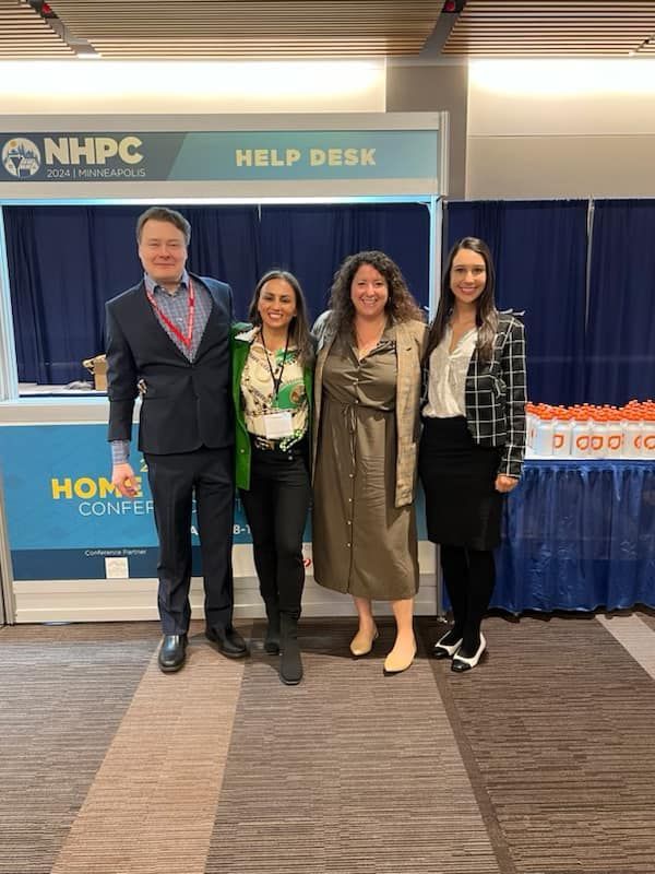 A group of people are posing for a picture in front of a help desk.