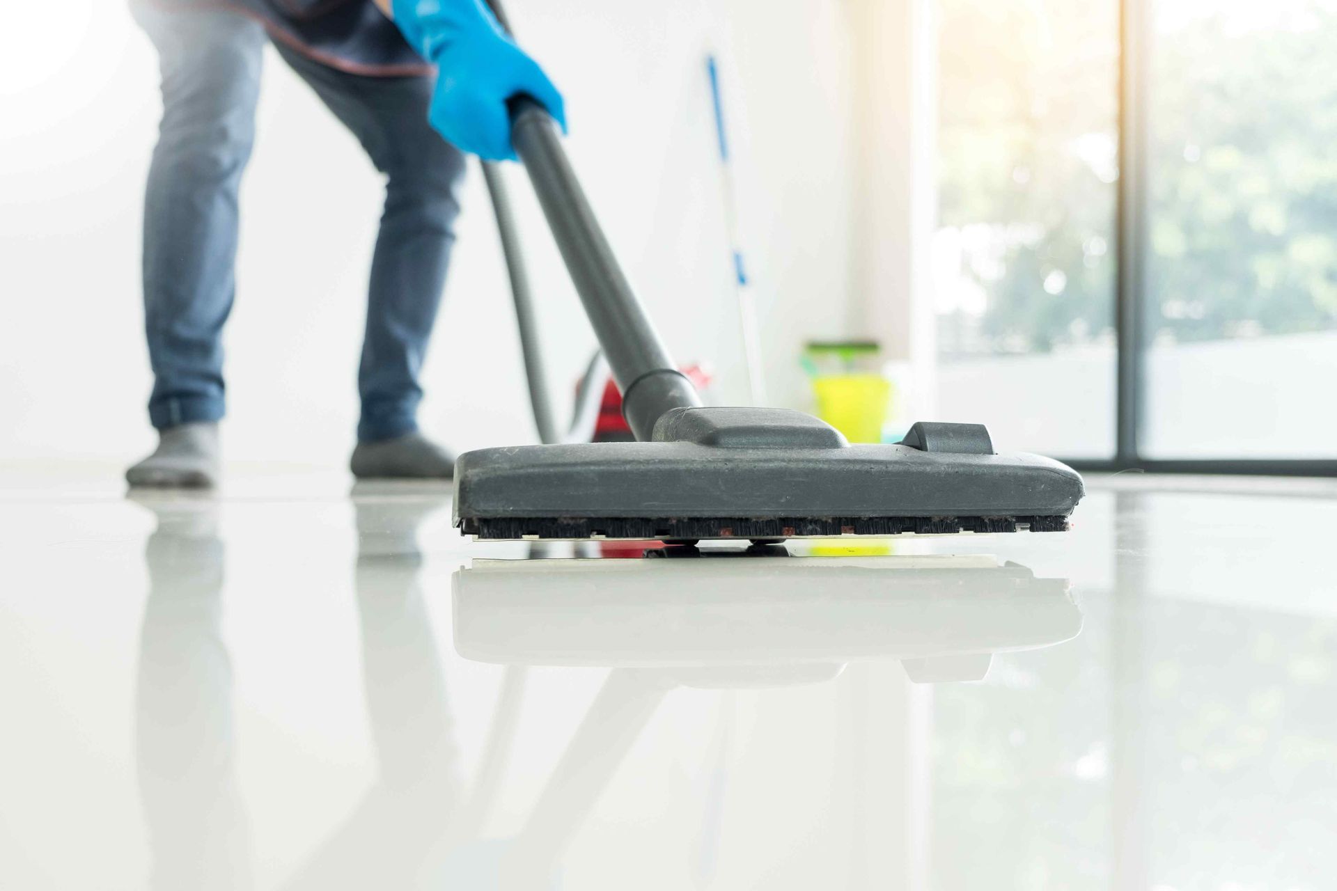 An employee cleaning tile flooring