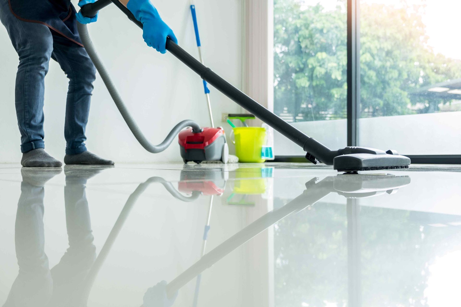 A team member using the proper equipment to clean a tile floor