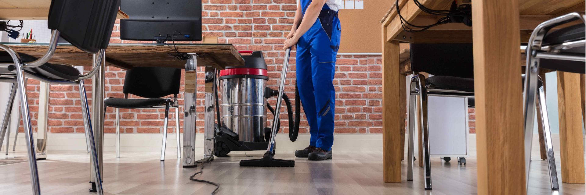 A team member cleaning a hardwood floor with specialized equipment